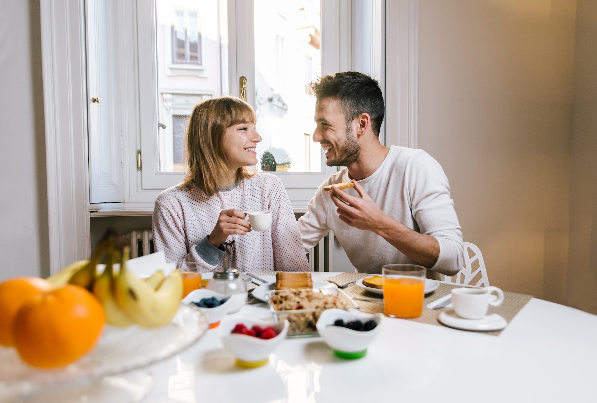 Happy couple having healthy breakfast together at home